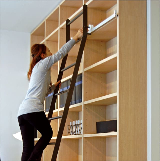 はしごは軽い力で左右に動かせます。天井付近の本の出し入れも容易です。